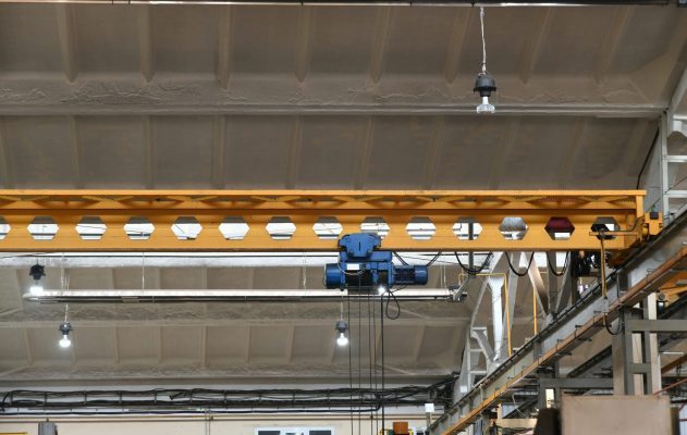 Pont roulant industriel déplaçant une charge dans un atelier de production