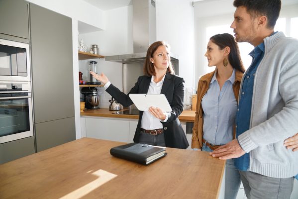 Couple with real-estate agent visiting house for sale